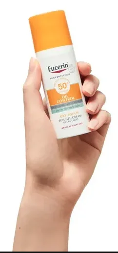 Mano cogiendo la crema Eucerin Oil Control Face Sun Gel-Creme