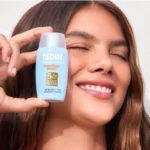 ISDIN Fotoprotección Fusion Water MAGIC SPF 50 con una mujer contenta.